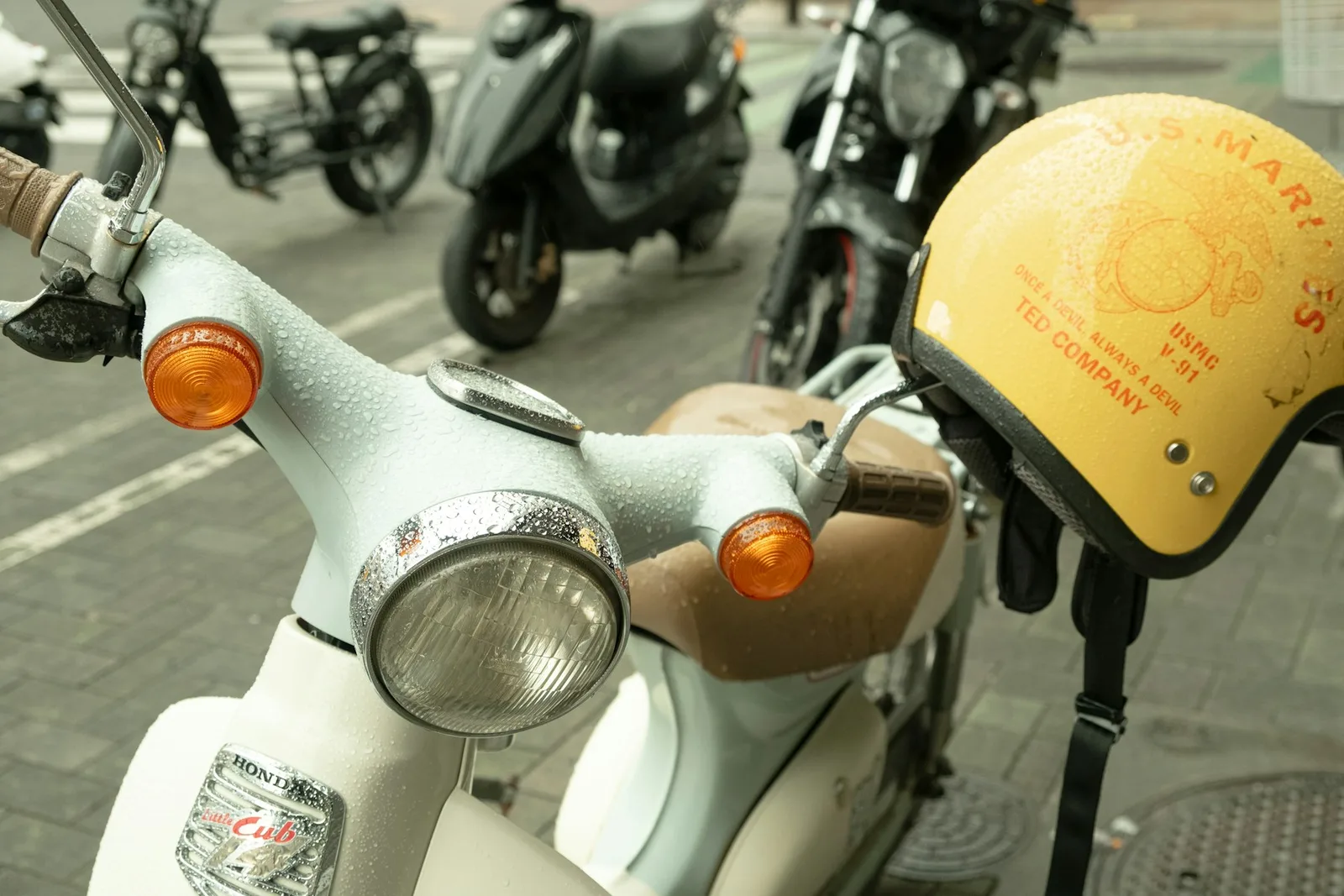 A Cub’s round headlamp and orange indicators beside a yellow helmet