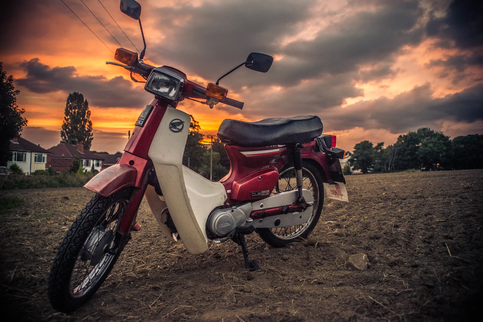 Marc Blackburn-Wilson’s burgundy Honda C90 beneath a glowing sunset in Horsforth, Leeds